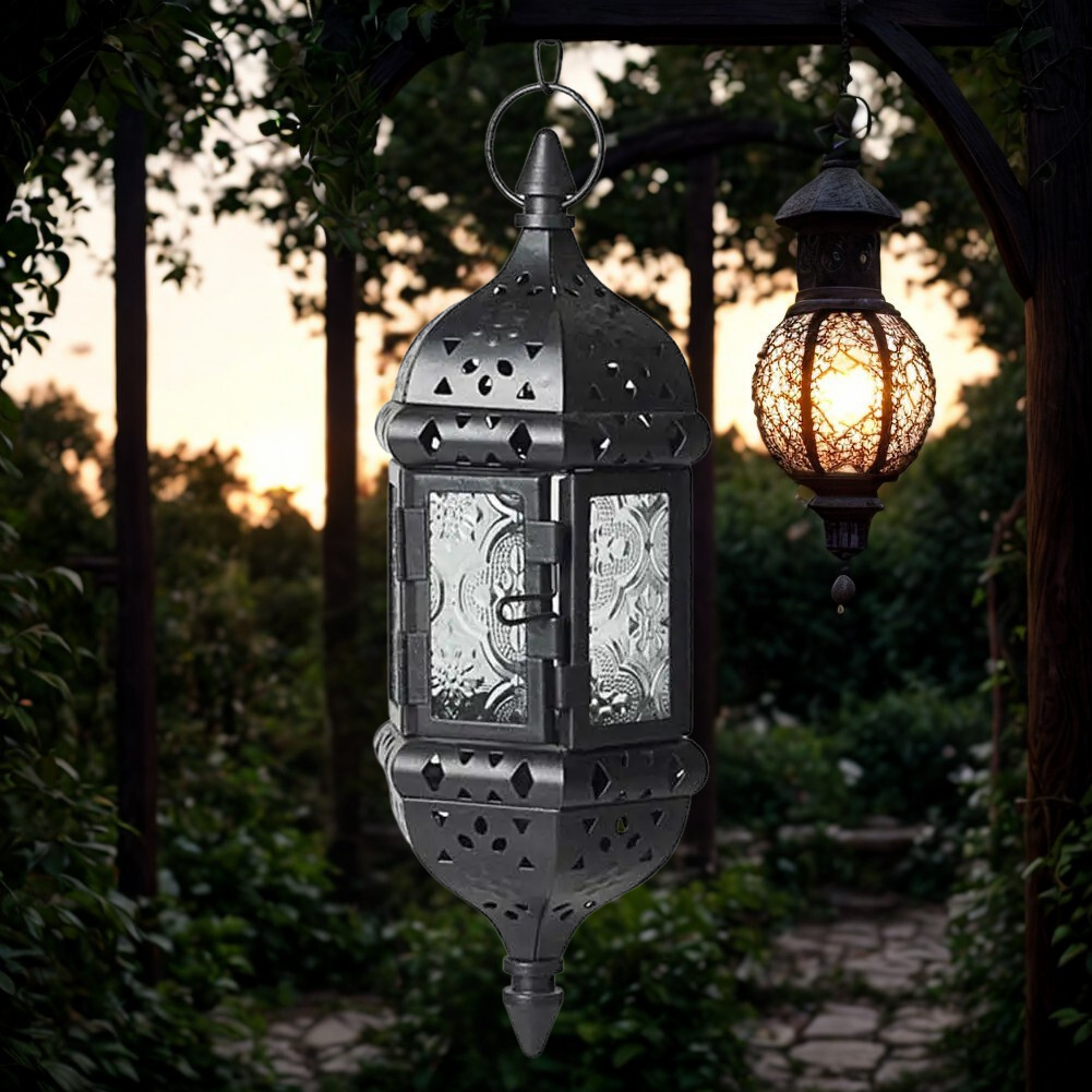 Hanglamp Baalbek – zwarte uitvoering met helder geperst glas en sierlijk metaalwerk, sfeervol in tuin bij zonsondergang